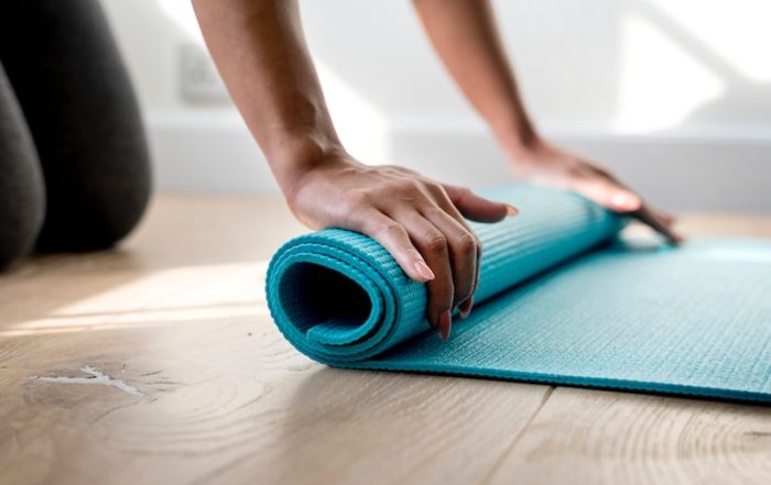woman rolling yoga mat